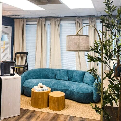 milestone treatment center's virginia beach facility interior with green couch and wood floors next to a window